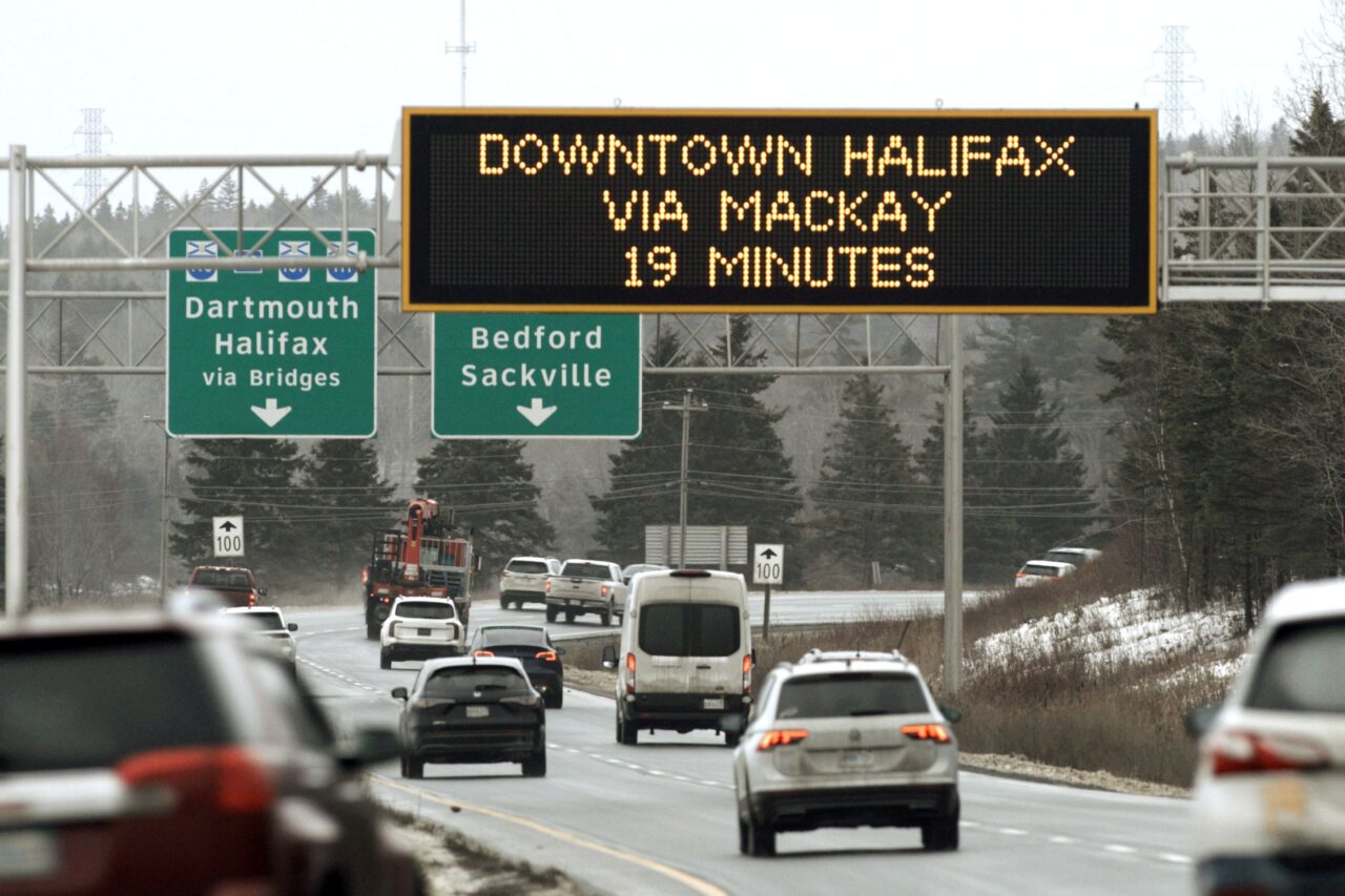 Vehicles travel on a highway toward Halifax. A large digital sign reads Downtown Halifax via Mackay 19 minutes.